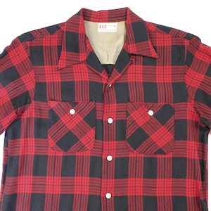 May include: A red and black plaid button-up shirt with two front pockets and white buttons. The shirt has a classic collar and a label at the neck. The B.V.D. label is visible.