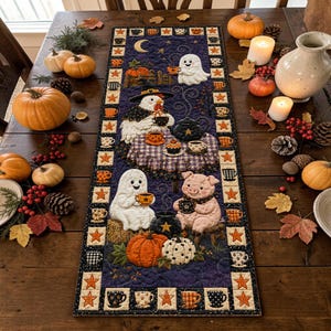 May include: A rectangular quilted table runner featuring a dark blue background with a Halloween-themed scene of a ghost, a chicken in a witch hat, and a pig drinking from cups. The border displays alternating orange stars and small patterned mugs.