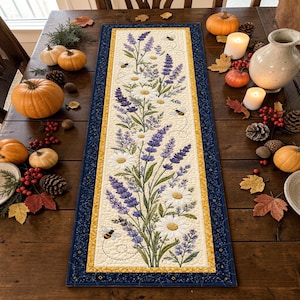Peut inclure: Un chemin de table matelassé rectangulaire présentant un panneau central crème avec un motif imprimé de brins de lavande violets, de marguerites blanches et de petites abeilles. Il possède une bordure intérieure jaune et une large bordure bleu foncé.
