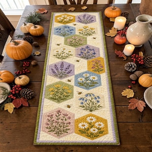 May include: A rectangular table runner featuring a cream-colored background with a repeating pattern of hexagonal blocks. Each hexagon displays embroidered floral motifs including daisies, lavender, and bluebells, accented by small bees.