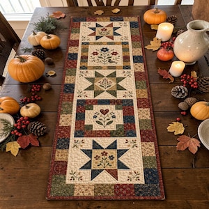 May include: A rectangular quilted table runner featuring a patchwork design with alternating star and floral blocks in shades of red, blue, green, and cream. The runner is decorated with embroidered motifs of flowers, leaves, and a small bird.