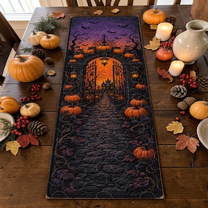 May include: A rectangular table runner featuring a printed Halloween scene of a stone archway, a cobblestone path, and a distant house under a purple and orange sky. The design includes numerous orange pumpkins, hanging lanterns, and flying bats.