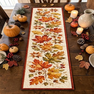 Puede incluir: Un camino de mesa acolchado rectangular con fondo color crema y un patrón central de hojas otoñales en tonos naranja, rojo, amarillo y verde, intercalado con pequeños motivos de estrellas geométricas y bellotas marrones.