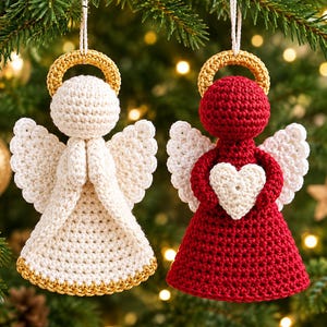 May include: Two crocheted angel ornaments hanging by white strings. One angel is cream-colored with a gold halo and hem, hands clasped in prayer. The other is deep red with a gold halo, white wings, and holding a small white crocheted heart.