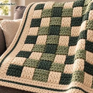 May include: A chunky crochet blanket featuring a checkered pattern in cream, sage green, and dark forest green. The blanket has a thick, textured border in cream and dark green. The text Babyblanketcrochet7 is visible in the top left corner.