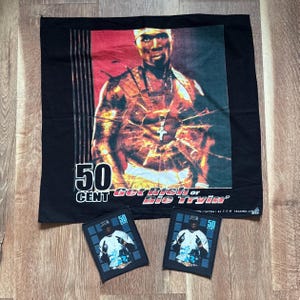 Könnte beinhalten: Ein schwarzes Stoffquadrat mit einer großen Grafik von 50 Cent und dem Text 50 CENT Get Rich or Die Tryin'. Darunter befinden sich zwei kleinere, passende rechteckige Stoffaufnäher, die jeweils eine Grafik von 50 Cent in einem weißen Hemd zeigen.