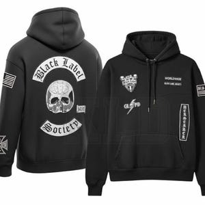 Op de afbeelding: Een zwarte hoodie met witte grafische prints. De achterkant toont een schedel met de tekst Black Label Society. De voorkant bevat patches met de tekst Worldwide, Black Label Society en Berserker, plus een bliksemschicht.