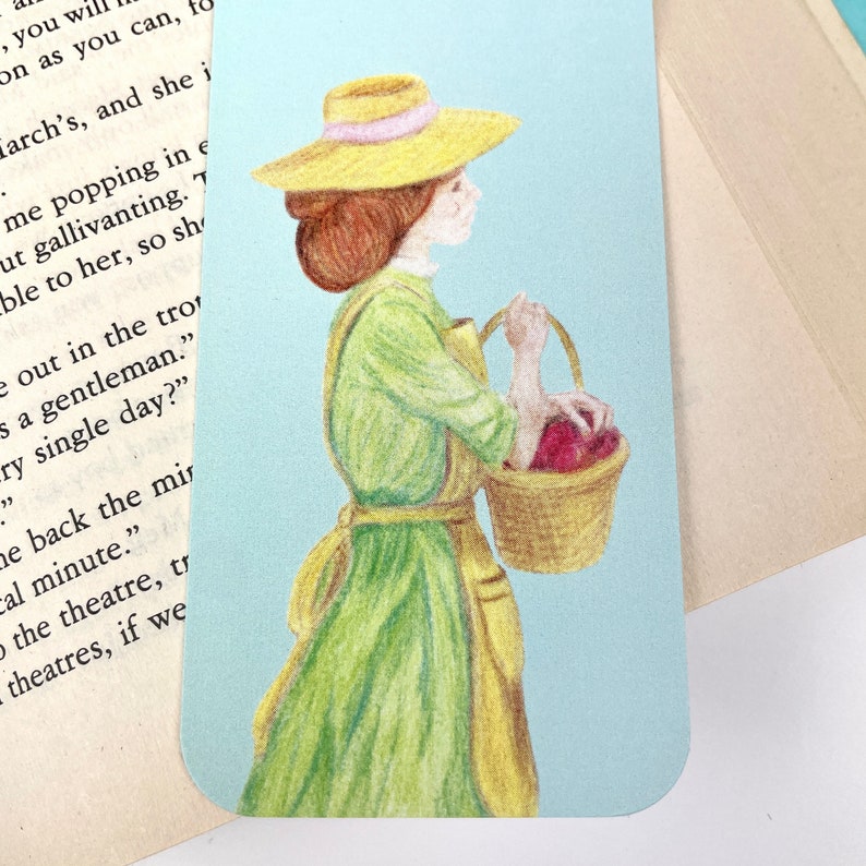 May include: A woman in a green dress and a straw hat carries a basket of red apples. The background is a light blue colour.
