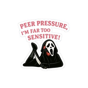 May include: A sticker featuring a figure in a black hooded robe and white ghost mask lying down while holding a red phone and a silver knife. Above the figure, pink text reads: PEER PRESSURE, I'M FAR TOO SENSITIVE! The design has a white border.