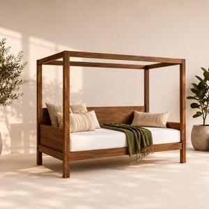 Peut inclure: Un lit de repos à baldaquin en bois doté d'un cadre rectangulaire à quatre montants verticaux. Le lit comprend un matelas blanc, deux coussins rectangulaires à motif beige texturé et un jeté de lit vert olive drapé.