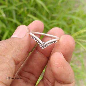 May include: A V-shaped silver ring featuring a beaded texture along the outer edge. The band has a smooth, polished finish on the inner side and a pointed chevron design. The text 925SilverBohoArt is visible in the bottom left corner of the image.