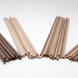 May include: Four distinct bundles of thin, straight wooden strips arranged in a fan-like formation. The bundles vary in color, ranging from a dark brown to a light tan and a medium reddish-brown, each featuring a smooth, rectangular cross-section.