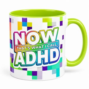 May include: A white ceramic mug with a lime green interior and handle. The exterior features a colourful pixelated pattern and the text "NOW THAT'S WHAT I CALL ADHD" in bold, multi-coloured letters with a rainbow gradient outline and blue border.