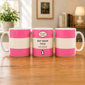 May include: Three ceramic mugs featuring a horizontal pink and white striped design. The centre mug displays the text PENGUIN BOOKS, ANY BOOK TITLE, and ANY AUTHOR, with a small black penguin graphic at the bottom, mimicking a classic book cover.