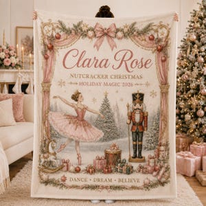 May include: A cream-colored throw blanket featuring a pink ballerina and a nutcracker, with the text Clara Rose, Nutcracker Christmas, Holiday Magic 2026, and Dance, Dream, Believe. The design includes pink curtains, ornaments, and gifts.