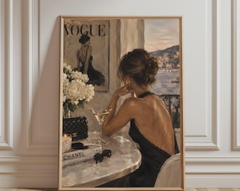 May include: A framed oil painting print depicting a person with an updo hairstyle wearing a black backless dress, seated at a table with a martini glass, a quilted black handbag, a candle, and books labelled Chanel and Kinfolk, near a Vogue poster.