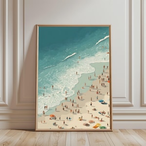 May include: A framed vertical art print depicting an aerial view of a crowded beach with turquoise ocean waves washing onto light tan sand. Numerous small figures are scattered across the shore, some swimming in the water and others relaxing under colorful beach umbrellas.