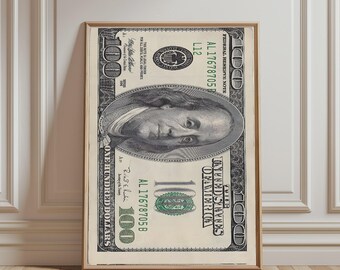 May include: A framed wall art print featuring a detailed, enlarged reproduction of a United States one hundred dollar bill. The design displays the portrait of Benjamin Franklin, the number 100, and the text United States of America.