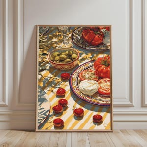 Pode incluir: Uma impressão de arte emoldurada retratando uma mesa mediterrânea com uma tigela de azeitonas verdes, um prato de tomates vermelhos fatiados e queijo mozzarella branco, e cerejas vermelhas espalhadas sobre uma toalha de mesa listrada.