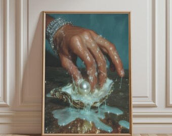 May include: A framed art print featuring a hand adorned with a sparkling silver bracelet, covered in a thick white viscous substance, reaching into an open oyster shell containing a single large, smooth, white pearl.