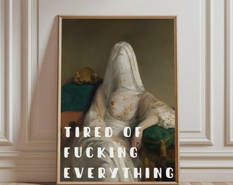 May include: A framed wall art print featuring a figure draped in a white veil, seated on a green upholstered chair. The figure wears a white gown with gold floral patterns. The text TIRED OF FUCKING EVERYTHING is printed in white.