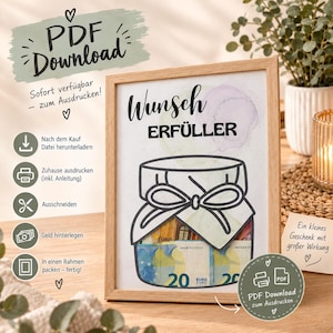 May include: A digital PDF download print featuring the text 'Wunsch ERFÜLLER' above a line-art illustration of a glass jar. The jar graphic contains visible 20 Euro banknotes. The print is displayed in a light wood frame on a flat surface.