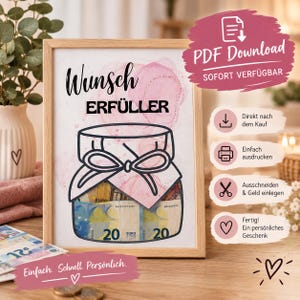 May include: A framed print featuring the German text Wunsch ERFÜLLER above a line drawing of a glass jar with a bow. The jar contains visible 20 Euro banknotes. The background of the print has a soft pink watercolour wash effect.