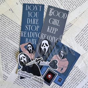 Op de afbeelding: Twee rechthoekige boekenleggers met een donkerblauwe achtergrond en witte tekst. De een leest DON'T YOU DARE STOP READING BABY, de ander GOOD GIRL, KEEP READING. Bevat stickers van een gemaskerd figuur, een mes, een hart en een schedel met roos.