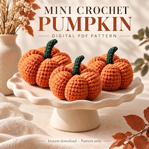 Puede incluir: Tres calabazas de ganchillo naranjas con tallos verde oscuro sobre un pedestal beige festoneado. El texto dice MINI CROCHET PUMPKIN DIGITAL PDF PATTERN e Instant download Pattern only. Las calabazas tienen una superficie de hilo.