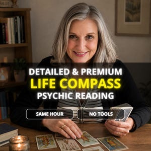 May include: A person with shoulder-length gray hair wearing a black cardigan over a striped shirt, sitting at a wooden table with tarot cards. Text overlay reads: DETAILED & PREMIUM LIFE COMPASS PSYCHIC READING, SAME HOUR, NO TOOLS.