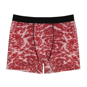 Peut inclure: Caleçon avec un motif réaliste de viande marbrée rouge et blanche sur tout le tissu. Le vêtement comprend une ceinture élastique noire unie et des coutures noires le long des empiècements avant, offrant un contraste net avec l'imprimé.