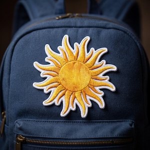 May include: A navy blue canvas backpack featuring a large, circular embroidered sun patch. The sun design has a golden yellow center with radiating, flame-like yellow and orange rays, all outlined with a thick white border stitched onto the fabric.