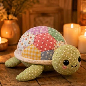 May include: A stuffed turtle toy featuring a patchwork shell made of various pastel-coloured fabric hexagons with floral, polka dot, and gingham patterns. The head and limbs are made of light green fabric with small white dots, black eyes, and pink cheeks.