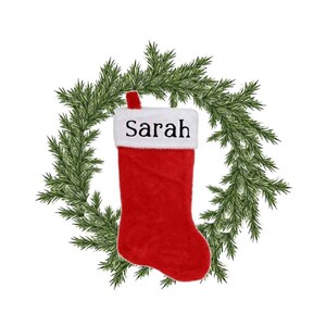 May include: Red Christmas stocking with a white cuff and the name "Sarah" embroidered on it. The stocking is surrounded by a green pine wreath.