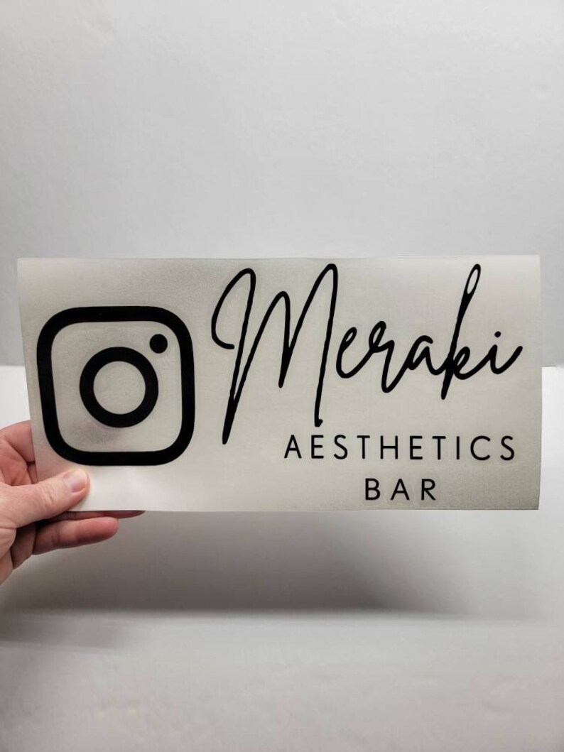 Puede incluir: Logotipo de Instagram en blanco y negro con el texto "Meraki Aesthetics Bar" debajo.