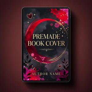 May include: A digital tablet displaying a book cover design with a black background, red watercolor splashes, and gold accents. The text reads PREMADE BOOK COVER and AUTHOR NAME. The design features a large red crescent, hearts, and foliage.