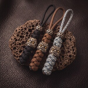 Portachiavi in paracord con leone del risveglio in rame anticato, realizzato a mano - Ciondolo per coltello EDC e borsa da esterno