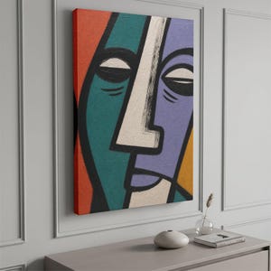 May include: A rectangular canvas wall art piece featuring a stylised, abstract face divided into sections of teal, purple, orange, and yellow. The face is defined by thick black outlines, a prominent white central nose, and closed eyes with dark lashes.