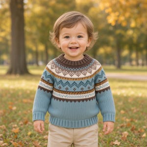Pode incluir: Uma camisola de malha de manga comprida com base azul e um padrão Fair Isle multicolorido no peito e nos ombros, incluindo formas geométricas castanhas, brancas e bege, com gola redonda e punhos canelados.