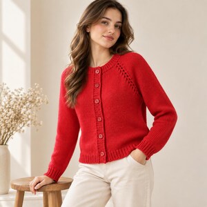May include: A vibrant red long-sleeve knit cardigan featuring a round neckline, a vertical row of matching red buttons down the center front, and ribbed cuffs and hem. The garment is constructed with a textured knit pattern and raglan sleeves.