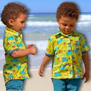 Op de afbeelding: Twee jonge jongens dragen korte mouwen knoophemden met een groene en gele achtergrond en een natuurthema print. De shirts hebben een blauwe rand rond de kraag en manchetten. De jongens staan op een strand.