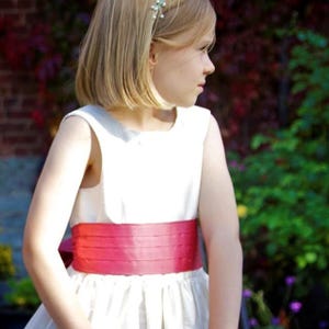 Flower girl dress pdf sewing pattern, cummerbund sash, big bow, classic flower girl frock, pink sash, cream bodice, covered buttons, rouleaux loop fastening. Free You Tube Video playlist. Back view of the handcovered cover buttons.