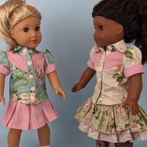 Puede incluir: Dos muñecas con vestidos de estampado floral con detalles en rosa. La muñeca de la izquierda lleva un vestido de estampado floral azul y verde con una falda rosa. La muñeca de la derecha lleva un vestido de estampado floral beige y verde con una falda de capas.