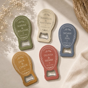 Può includere: Cinque apribottiglie in verde oliva, crema, blu ardesia, giallo senape e rosso terracotta. Ognuno presenta una parte superiore arrotondata con testo stampato in bianco The Wedding Of, nomi, un cuore e una data, incorniciati da delicate foglie.