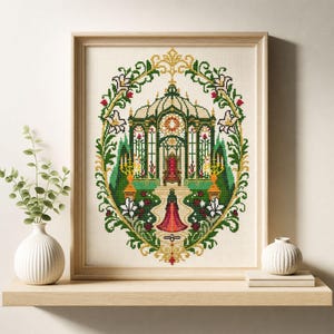 May include: A framed cross-stitch embroidery featuring a central greenhouse structure with a red throne inside, surrounded by a decorative oval border of green vines, white lilies, and red roses, with a figure in a red dress standing below.