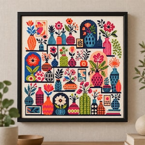 May include: A square cross-stitch embroidery in a black frame featuring a grid of colorful vases and potted flowers in shades of pink, orange, blue, and green. The design includes various geometric patterns on the vases and small framed art pieces.