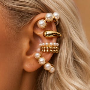 Set van 4 gouden en parel oormanchetten, robuust en minimalistisch, zonder piercing.