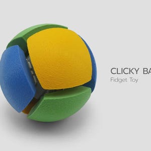 May include: A spherical fidget toy composed of interlocking segments in yellow, blue, and green. The surface of each segment features a fine, circular 3D-printed texture. The text "CLICKY BALL Fidget Toy" is printed to the right of the object.