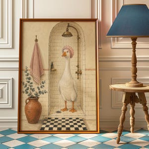 May include: A framed wall art print depicting a white goose wearing a pink shower cap while standing in a tiled shower stall. The scene includes a brass shower head, a hanging pink towel, a terracotta vase with eucalyptus, and a checkered floor mat.