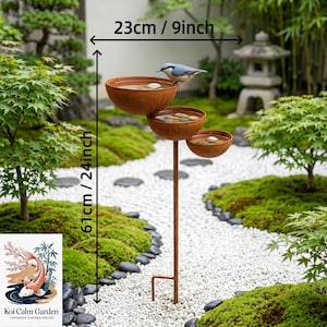 May include: A tiered bird bath featuring three rust-colored metal bowls on a single pole, with a small bird perched on the top bowl. The structure measures 23 inches in width and 61 inches in height, as indicated by the visible measurement text.